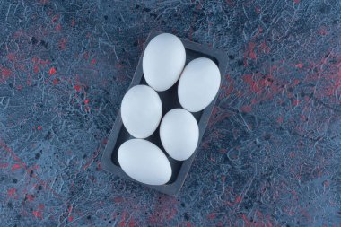 Çiğ beyaz tavuk yumurtaları olan koyu tahta bir tahta. Yüksek kalite fotoğraf