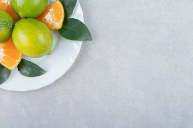 Beyaz tabakta limon ve mandalina dilimleri. Yüksek kalite fotoğraf