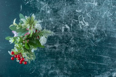 Mavi arka planda, bir bardakta çeşitli çiçekler. Yüksek kalite fotoğraf
