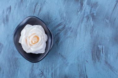 Mavi arka planda beyaz gül çiçekli siyah bir plaka. Yüksek kalite fotoğraf