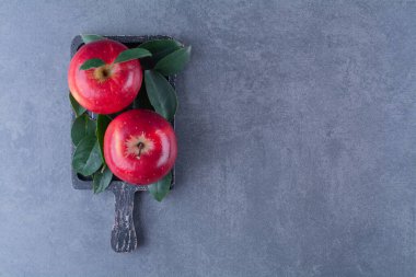 Üzerinde yapraklar olan olgun elmalar, mermer arka planda. Yüksek kalite fotoğraf