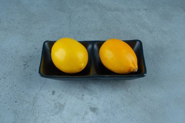 Siyah kasedeki limonlar, mermer arka planda. Yüksek kalite fotoğraf