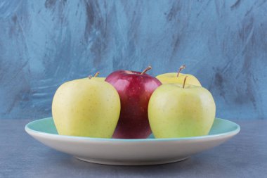 Tabakta sarı ve kırmızı elmalar, mermer arka planda. Yüksek kalite fotoğraf