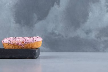 Kesme tahtasına serpiştirilmiş pembe tatlı çörek. Yüksek kalite fotoğraf