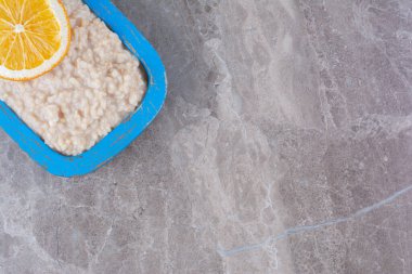 Lezzetli yulaf ezmesi ve bir dilim portakal meyvesi olan ahşap bir tahta. Yüksek kalite fotoğraf