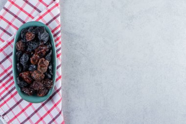 Taş zeminde mavi bir kase lezzetli kurutulmuş hurma. Yüksek kalite fotoğraf