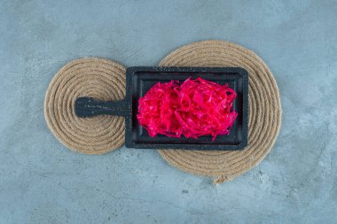 Mavi arka planda, trivet tahtasında lahana turşusu. Yüksek kalite fotoğraf