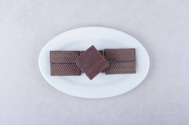 Çikolata kaplı gofretler bir tabakta, mermer arka planda. Yüksek kalite fotoğraf