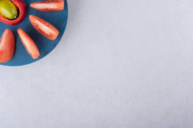 Dilimlenmiş domates ve biber tabakta, mermer zemin üzerinde. Yüksek kalite fotoğraf