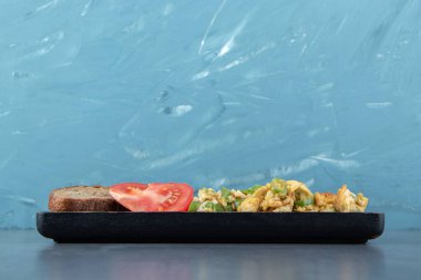 Lezzetli kızarmış yumurta ve siyah tabakta çavdar ekmeği dilimi. Yüksek kalite fotoğraf