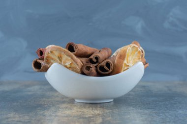 Mermer arka planda bir kase tarçın çubuğu. Yüksek kalite fotoğraf