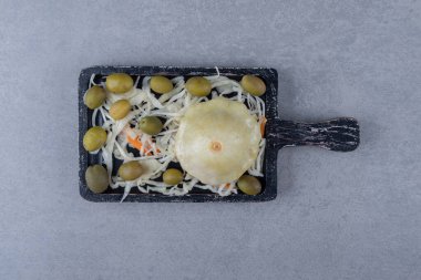 Mini kabak, zeytin, lahana turşusu tepside, mermer arka planda. Yüksek kalite fotoğraf