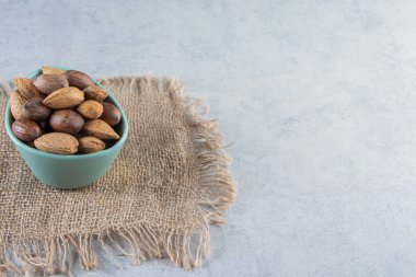 Taş zemin üzerinde kabuklu badem ve ceviz kasesi. Yüksek kalite fotoğraf