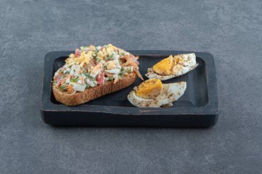 Salatalı ekmek ve siyah tabakta haşlanmış yumurta. Yüksek kalite fotoğraf