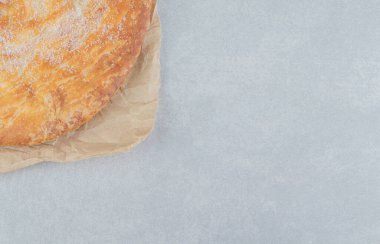 Kağıt üzerinde beyaz pudrayla süslenmiş yuvarlak pasta. Yüksek kalite fotoğraf