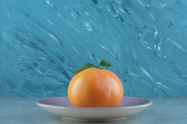 Mermer zemin üzerinde taze turuncu bir tabak. Yüksek kalite fotoğraf