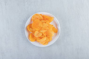 Taş zemine yerleştirilmiş beyaz tabak baharatlı cips. Yüksek kalite fotoğraf