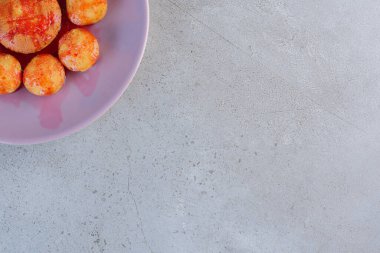 Arka planda çilek sosu olan mor bir tabak mini kek. Yüksek kalite fotoğraf