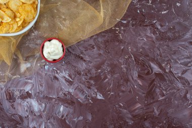 Patates cipsi ve yoğurt mermer arka planda, tülün üzerinde bir tabakta. Yüksek kalite fotoğraf
