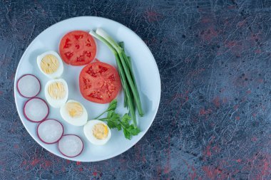 Mavi bir tabak haşlanmış yumurta ve sebze. Yüksek kalite fotoğraf