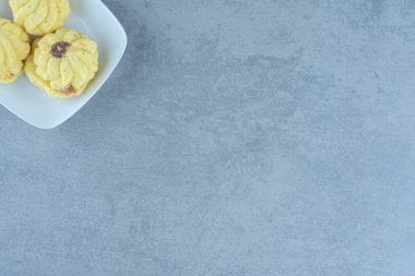 Beyaz tabakta ev yapımı sarı kurabiyelerin üst görüntüsü. Yüksek kalite fotoğraf