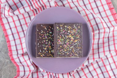 Tahtadaki çikolatalı waffle 'ın üzerine şeker serpilmiş, mermer arka planda. Yüksek kalite fotoğraf