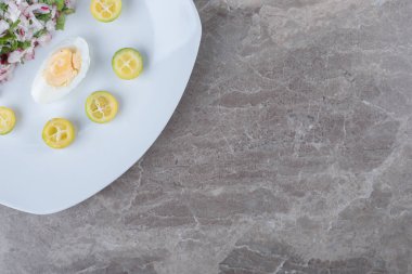 Beyaz tabakta garnitür olarak salata ile haşlanmış yumurta. Yüksek kalite fotoğraf