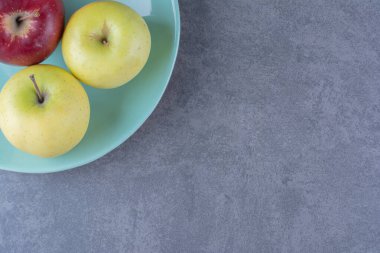 Tabakta sarı ve kırmızı elmalar, mermer arka planda. Yüksek kalite fotoğraf