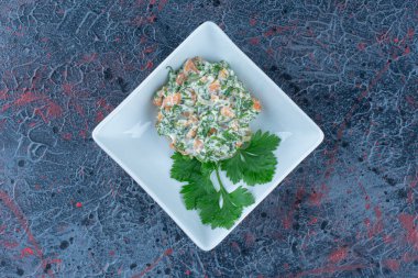 Lezzetli salata ve otlarla dolu beyaz bir tabak. Yüksek kalite fotoğraf