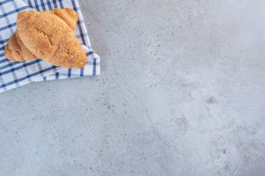 Taş zeminde masa örtüsü olan iki lezzetli kruvasan. Yüksek kalite fotoğraf