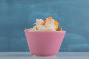 Mermer arka planda, kâsede lezzetli sebze turşusu. Yüksek kalite fotoğraf