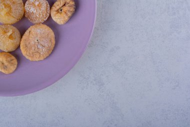 Mor tabağa konmuş bir demet kurutulmuş incir. Yüksek kalite fotoğraf