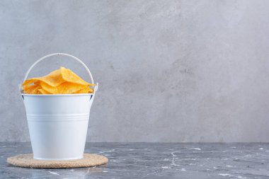 Mermer kaplamalı bir kovada çıtır patates cipsi. Yüksek kalite fotoğraf
