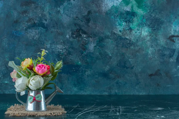 Sztuczne Kwiaty Puszce Podlewanie Niebieskim Tle Wysokiej Jakości Zdjęcie — Zdjęcie stockowe