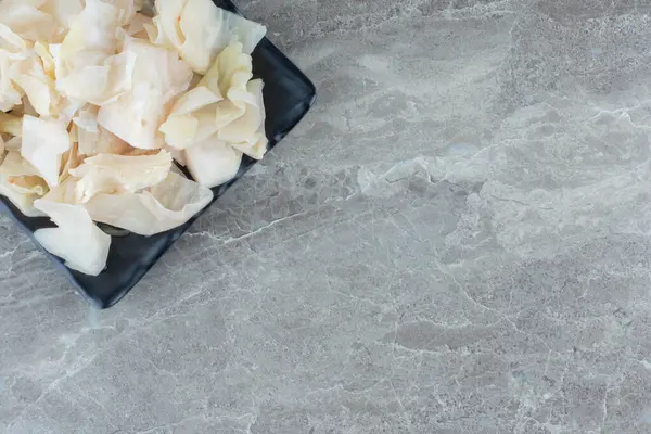 Siyah tabakta konserve beyaz lahana resmi. Yüksek kalite fotoğraf