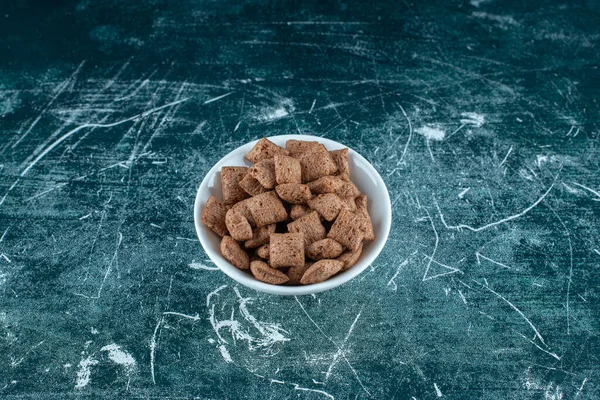 Mavi arka planda, bir kasedeki mısır yastıkları. Yüksek kalite fotoğraf