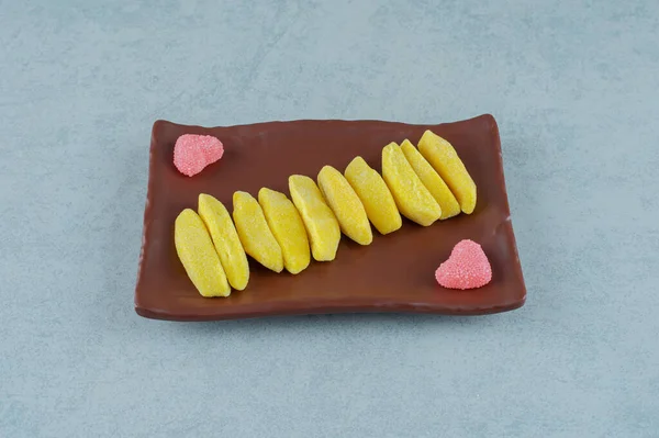 バナナの茶色のプレートは ハート型の砂糖マーマレードとキャンディを噛む形 高品質の写真 — ストック写真