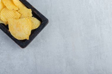 Siyah tabakta çıtır çıtır lezzetli cips yığını. Yüksek kalite fotoğraf