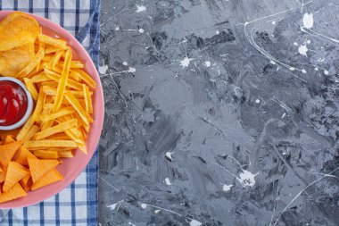 Patates kızartması ve patates kızartması havlunun üstünde, mermer sırt çantasında.