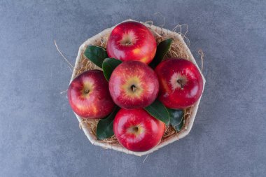 Bir sepet elma ve yaprak, mermer arka planda. Yüksek kalite fotoğraf