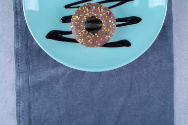 Renkli şekerli çöreklerden oluşan mavi bir tabak. Yüksek kalite fotoğraf