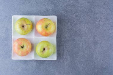 Mermer arka planda, tabakta taze elmalar. Yüksek kalite fotoğraf