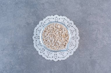 Mermer arka planda, bardak altlığında kabuklarda ayçekirdeği kabuğu soyuluyor. Yüksek kalite fotoğraf