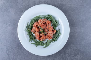 Terbiye edilmiş tavuk parçaları ve beyaz tabakta tarhun otu. Yüksek kalite fotoğraf