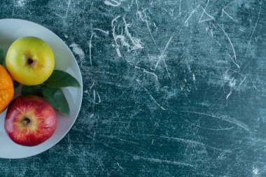 Elma, portakal ve yapraklar mermer arka planda. Yüksek kalite fotoğraf