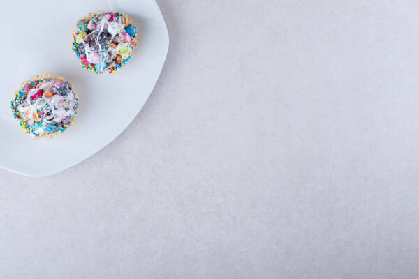 Mini tart cakes on a plate, on the marble background