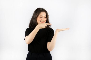 Gülümseyen güzel kız, boş elini işaret ediyor.