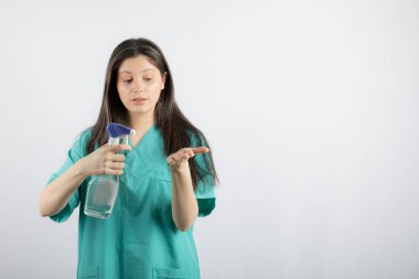 Covid-19 sırasında. Genç hemşire elini dezenfekte ediyor.