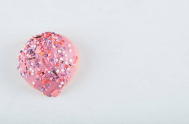 Beyaz arkaplanda şekerli pembe kurabiye