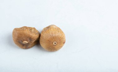 Beyaz arka planda iki kuru incir.